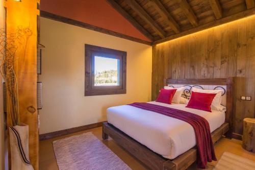 a bedroom with a bed with red pillows and a window at El BURGO DE OSMA ALOJAMIENTO RURAL VILLA BAGH in El Burgo de Osma