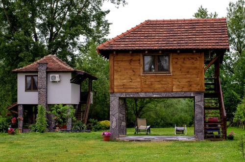 uma cabana de madeira com um gazebo num quintal em Drinska laguna em Banja Koviljača