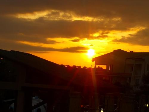 a sunset with the sun setting in the background at Holiday Beach Lumia in Sciacca