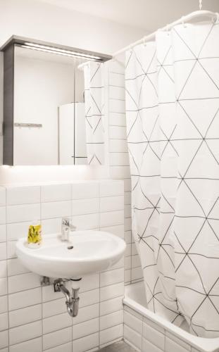 a white bathroom with a sink and a mirror at Altstadt Apartment Alisa in Düsseldorf