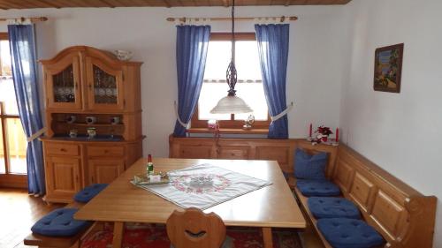a dining room with a wooden table and blue chairs at Haus Bergblick in Lindberg