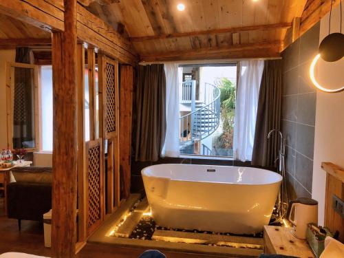 a large bath tub in a room with a window at Lijiang Yunqi Holiday Guesthouse in Lijiang