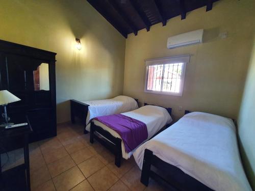 a room with two beds and a window at Cabañas Mburucuyá Poty in Mburucuyá