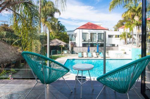 a patio with a table and chairs next to a pool at Terrigal Pacific Coastal Retreat in Terrigal