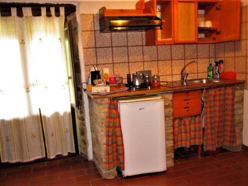 a kitchen with a white refrigerator and a sink at La Pietra Rara B&B in Montone
