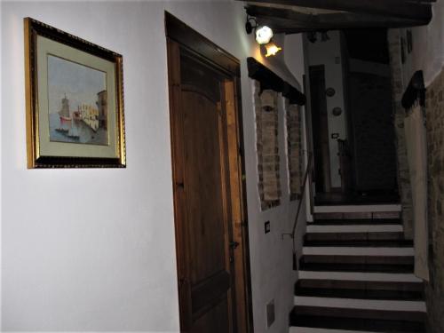 a hallway with stairs and a door and a picture at La Pietra Rara B&B in Montone