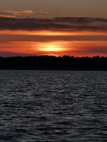 a sunset over a large body of water at VilaRita in Nida