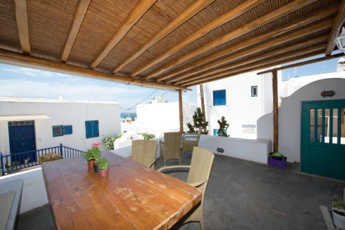 a wooden table on a balcony with a green door at Hibiscus Rosa Mykonos in M&yacute;konos City