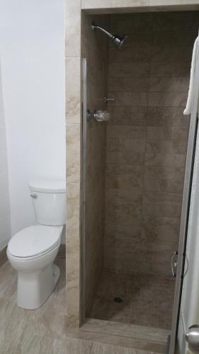 a bathroom with a toilet and a glass shower at Thunder Bird Motel in Mountain Home
