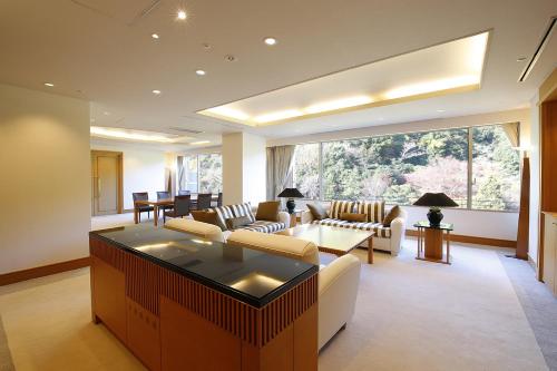 a living room with white furniture and a large window at Arima Onsen Gekkoen Korokan in Kobe