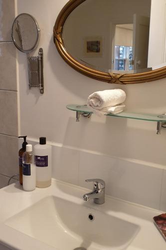 a bathroom with a sink and a mirror at Astley Cottage in Daylesford