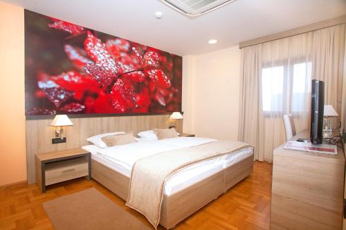 a bedroom with a bed and a large painting on the wall at Hotel Calypso in Zagreb