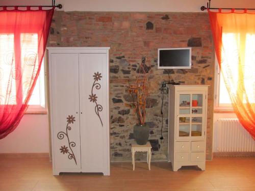 a room with a white cabinet and a brick wall at Monolocale Borgo Antico in Castelnuovo di Val di Cecina