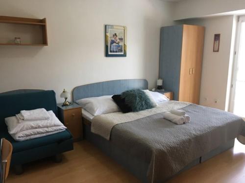a bedroom with a blue bed and a blue chair at Guest House Maxim in Liptovský Mikuláš
