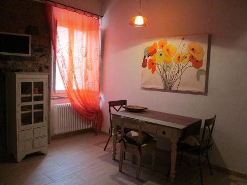 une salle à manger avec une table et un tableau mural dans l'établissement Monolocale Borgo Antico, à Castelnuovo di Val di Cecina