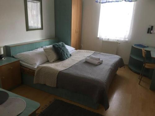 a bedroom with a bed with two towels on it at Guest House Maxim in Liptovský Mikuláš