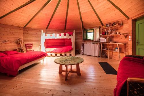 una habitación con 2 camas y una mesa en una cabaña en Les Ecuries de La Sabatarié en Cambounès