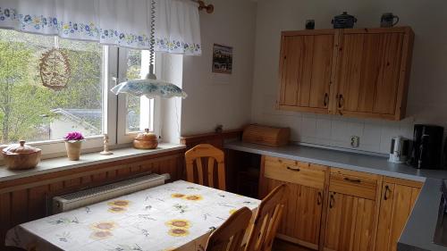 a kitchen with a table with chairs and a window at Ferienwohnung Grenzblick in Kurort Oberwiesenthal