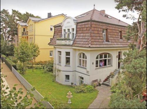 a large white house with a brown roof at Villa Harmonie in Ahlbeck