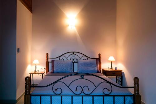 a bedroom with a bed with two lamps on the wall at Spacious Retreat near Preveli, Triopetra & Plakias in Dharivianá