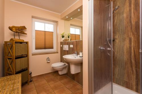 a bathroom with a toilet and a sink and a shower at Waldidyll in Ostseebad Karlshagen