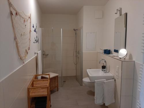 a white bathroom with a toilet and a sink at Residenz Bollwark Port Olpenitz in Kappeln