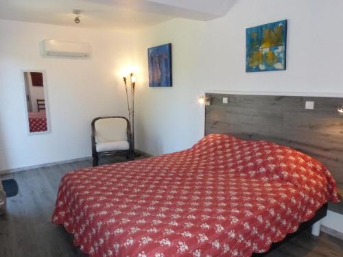 - une chambre avec un lit rouge et une chaise dans l'établissement Chambre d'Hôtes L'Odalyre, à Moustiers-Sainte-Marie