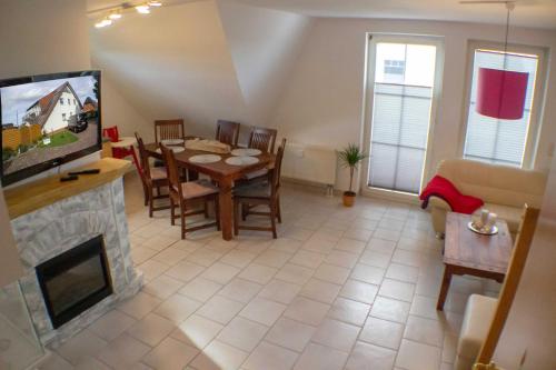 ein Wohnzimmer mit einem Esstisch und einem TV in der Unterkunft Ferienwohnung Ostseefeeling 3 in Ostseebad Karlshagen