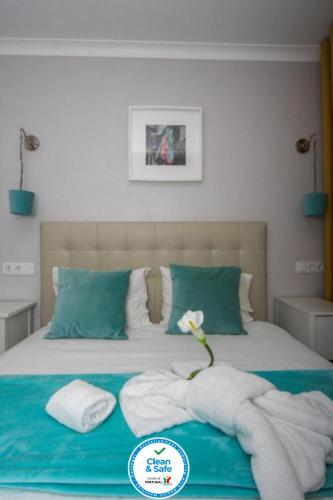 a bedroom with a bed with towels on it at Ferhouse Dreams Pátria in Nazaré
