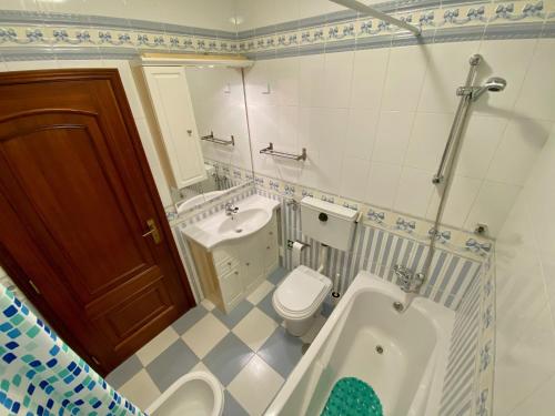 a bathroom with a tub and a toilet and a sink at Altura da Maré - Apartamento Duna in Altura