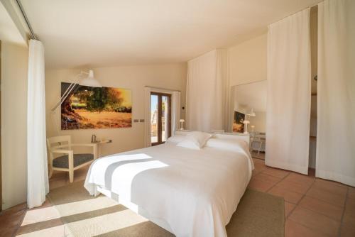 um quarto com uma grande cama branca com lençóis brancos em Cortijo LA Organic em Ronda