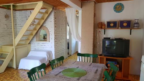 a room with a table and a bed and a television at Napraforgó Vendégház in Gárdony