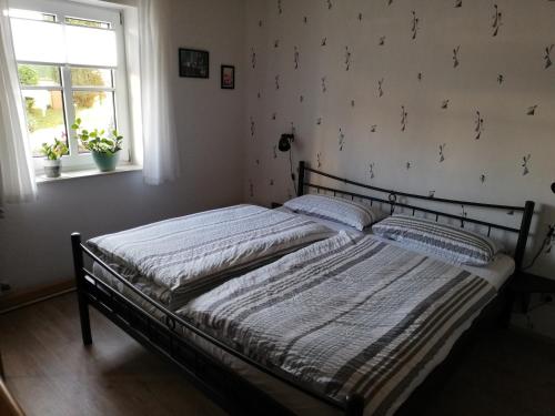 a bed sitting in a bedroom with a window at Ferienwohnung Eifelgold Esch in Esch