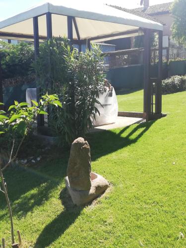 a stone statue sitting in the grass in a yard at A cà ed Franca e Giaco in La Morra