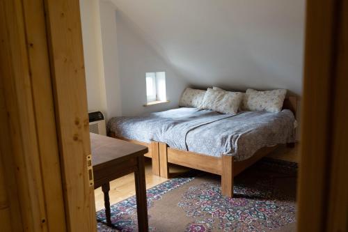 um pequeno quarto com uma cama e uma mesa em Садиба в пані Рузі em Skole