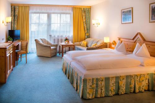 a hotel room with two beds and a living room at Hotel Zum Stern - Bergbahnen inklusive im Sommer 2025 in Bad Hofgastein