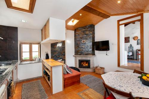 a kitchen with a living room with a fireplace at Casa da Quiana in Digueifel