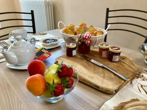 a table with strawberries and jam and a bowl of fruit at PekerHouse in Bosmenso Superiore