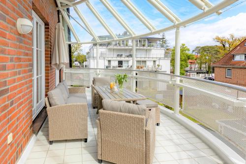 patio con mesa y sillas en el balcón en Techts Strandhaus en Timmendorfer Strand
