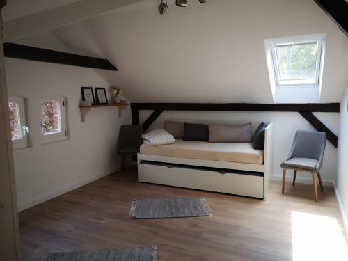 a small room with a bed and a chair at Lüttje Heide-Huus in Soltau