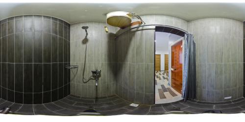 a bathroom with a shower and a mirror at Green Yard Hotel in Karakol