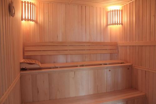 a sauna with wooden shelves and lights in it at Green Yard Hotel in Karakol