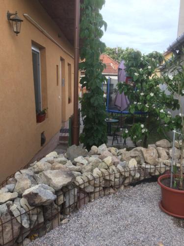 a stone retaining wall in a yard next to a building at BORINA VENDÉGHÁZ in Sátoraljaújhely