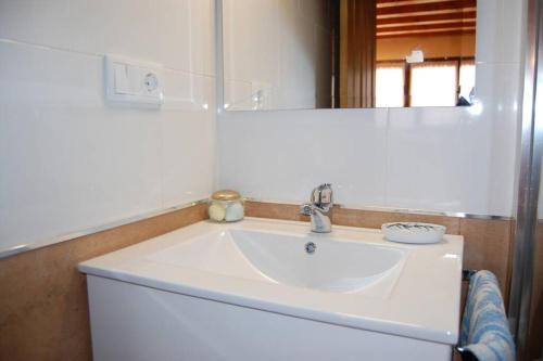 lavabo blanco en el baño con espejo en La Casina de Cirieñu, en Pen
