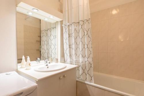 uma casa de banho com um lavatório, um espelho e um chuveiro em T2 proche Disneyland Paris em Meaux