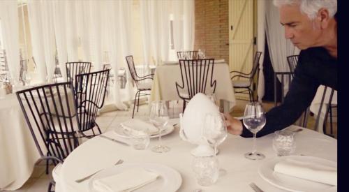 a woman is standing at a table with a glass at Le Nicchie Guest House in Lucera