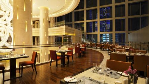 a restaurant with tables and chairs in a building at Kempinski Hotel Taiyuan in Taiyuan