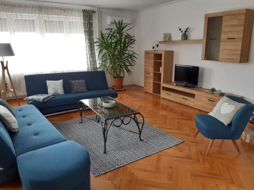a living room with a blue couch and a table at Apartman Nikol in Tihany