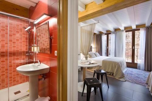 łazienka z umywalką i łóżkiem w pokoju w obiekcie La Casa De Santa María ESTUDIOS w mieście Vitoria-Gasteiz