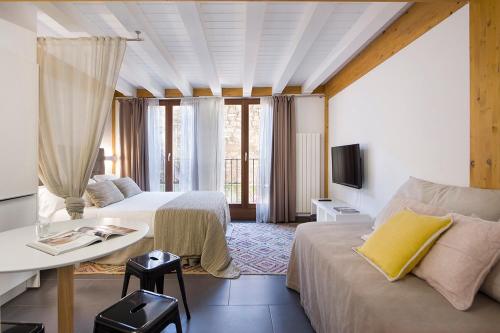 sypialnia z 2 łóżkami, stołem i kanapą w obiekcie La Casa De Santa María ESTUDIOS w mieście Vitoria-Gasteiz